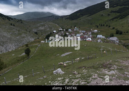 Lukomir, Bosnien. 9. Juli 2018. Das kleine Dorf Lukomir aus der Ferne gesehen. In den Bergen oberhalb von Sarajevo auf etwa 1500 Meter liegt Lukomir, der am weitesten entfernten Dorf in ganz Bosnien. Das Dorf besteht hauptsächlich aus Nomaden Schafe herder, adn eine Bevölkerung von etwa 20 Personen. Als unstrategic durch die Serben, Lukomir ist einer der wenigen Bereiche, die während des Krieges in den 1990er Jahren unberührt blieb. Die Bevölkerung des Dorfes wird langsam verschwinden. Mit Kindern der Schule zu besuchen und an anderer Stelle nicht zurückkommen, was ist die Zukunft dieses Dorf? Nach diesem aktuellen Gener Stockfoto