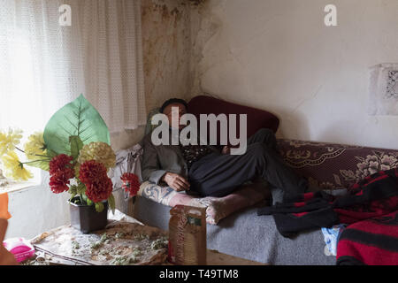 Lukomir, Bosnien. 9. Juli 2018. Ein Ältester Mann sitzt auf seiner Couch in seinem Hause. In den Bergen oberhalb von Sarajevo auf etwa 1500 Meter liegt Lukomir, der am weitesten entfernten Dorf in ganz Bosnien. Das Dorf besteht hauptsächlich aus Nomaden Schafe herder, adn eine Bevölkerung von etwa 20 Personen. Als unstrategic durch die Serben, Lukomir ist einer der wenigen Bereiche, die während des Krieges in den 1990er Jahren unberührt blieb. Die Bevölkerung des Dorfes wird langsam verschwinden. Mit Kindern der Schule zu besuchen und an anderer Stelle nicht zurückkommen, was ist die Zukunft dieses Dorf? Nach der aktuellen Generation Stockfoto