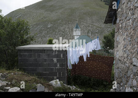 Lukomir, Bosnien. 9. Juli 2018. Wäsche trocknet, wie der örtlichen Moschee ist im Hintergrund zu sehen. In den Bergen oberhalb von Sarajevo auf etwa 1500 Meter liegt Lukomir, der am weitesten entfernten Dorf in ganz Bosnien. Das Dorf besteht hauptsächlich aus Nomaden Schafe herder, adn eine Bevölkerung von etwa 20 Personen. Als unstrategic durch die Serben, Lukomir ist einer der wenigen Bereiche, die während des Krieges in den 1990er Jahren unberührt blieb. Die Bevölkerung des Dorfes wird langsam verschwinden. Mit Kindern der Schule zu besuchen und an anderer Stelle nicht zurückkommen, was ist die Zukunft dieses Dorf? Nach diesem curre Stockfoto