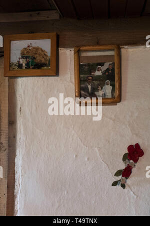 Lukomir, Bosnien. 9. Juli 2018. Fotos der Familie eines Menschen hängen an der Wand. Sie haben alle Links das Dorf. In den Bergen oberhalb von Sarajevo auf etwa 1500 Meter liegt Lukomir, der am weitesten entfernten Dorf in ganz Bosnien. Das Dorf besteht hauptsächlich aus Nomaden Schafe herder, adn eine Bevölkerung von etwa 20 Personen. Als unstrategic durch die Serben, Lukomir ist einer der wenigen Bereiche, die während des Krieges in den 1990er Jahren unberührt blieb. Die Bevölkerung des Dorfes wird langsam verschwinden. Mit Kindern der Schule zu besuchen und an anderer Stelle nicht zurückkommen, was ist die Zukunft dieses Dorf? Af Stockfoto