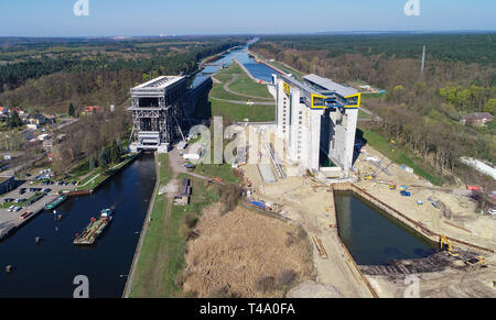 15. April 2019, Brandenburg, Niederfinow: Blick auf die Baustelle der neuen Schiff heben (r) und den alten Lift (l, Luftaufnahme mit einer Drohne). Seit 2009, der Wasser- und Schifffahrtsverwaltung des Bundes wurde die Errichtung eines neuen Schiffes heben Sie den alten technischen Denkmal auf der Oder-Havel-wasserstraße von 1934, das als einen Engpass auf dem Wasserweg von Berlin an die Ostsee zu ersetzen. Derzeit die unteren äußeren Hafen wird durch Bagger ausgegraben. Um dies zu tun, etwa 200.000 Kubikmeter Erde bewegt werden müssen. Den Testlauf des neuen Lift ist in ungefähr einem Jahr zu beginnen. Stockfoto