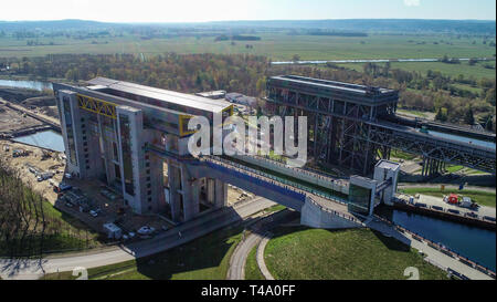 15. April 2019, Brandenburg, Niederfinow: Blick auf die Baustelle der neuen Schiff heben (l) und den alten Lift (r, Luftaufnahme mit einer Drohne). Seit 2009, der Wasser- und Schifffahrtsverwaltung des Bundes wurde die Errichtung eines neuen Schiffes heben Sie den alten technischen Denkmal auf der Oder-Havel-wasserstraße von 1934, das als einen Engpass auf dem Wasserweg von Berlin an die Ostsee zu ersetzen. Derzeit die unteren äußeren Hafen wird durch Bagger ausgegraben. Um dies zu tun, etwa 200.000 Kubikmeter Erde bewegt werden müssen. Den Testlauf des neuen Lift ist in ungefähr einem Jahr zu beginnen. Stockfoto