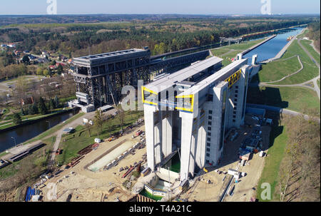 15. April 2019, Brandenburg, Niederfinow: Blick auf die Baustelle der neuen Schiff heben (r) und den alten Lift (l, Luftaufnahme mit einer Drohne). Seit 2009, der Wasser- und Schifffahrtsverwaltung des Bundes wurde die Errichtung eines neuen Schiffes heben Sie den alten technischen Denkmal auf der Oder-Havel-wasserstraße von 1934, das als einen Engpass auf dem Wasserweg von Berlin an die Ostsee zu ersetzen. Derzeit die unteren äußeren Hafen wird durch Bagger ausgegraben. Um dies zu tun, etwa 200.000 Kubikmeter Erde bewegt werden müssen. Führen Sie den Test Der neue Lift ist in etwa einem Ihr zu beginnen. Stockfoto