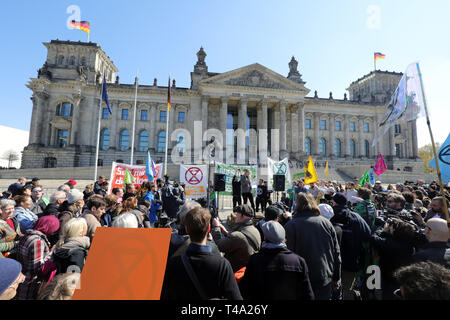 15 April 2019, Berlin: Demonstranten nehmen an einer Rallye von Aussterben Rebellion Deutschland vor dem Reichstag. Zwischen dem 15. und 27. April, die Bewegung will mehrere Aktionen des zivilen Ungehorsams gegen die Klimakrise durchzuführen und erläutert die Motive der Rebellion und der Aktion Spreebrücken. Foto: Wolfgang Kumm/dpa Stockfoto