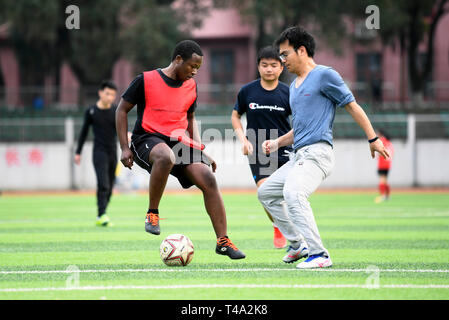 (190415) - CHANGSHA, April 15, 2019 (Xinhua) - Mangeh III Fondzenyuy Cedric (L) spielt Fußball mit Mitschülern in Hunan Landwirtschaftlichen Universität in Changsha, Provinz Hunan in China, 19. März 2019. Der 25-jährige Cedric ist aus Kamerun. In erweiterte landwirtschaftliche Chinesische Unternehmen "Wissenschaft und Technologie und Ausrüstung erlebt, er kam nach China in 2017 und studierte als Doktorand in der landwirtschaftlichen Mechanisierung Engineering in der Schule der Technik von Hunan Universität für Landwirtschaft studiert Nach seinem grundstudium. Cedric vor allem Studien landwirtschaftlichen mech Stockfoto