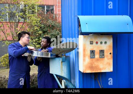 (190415) - CHANGSHA, April 15, 2019 (Xinhua) - Mangeh III Fondzenyuy Cedric (R) und sein Schulfreund Trocknungsanlagen in Hunan Landwirtschaftlichen Universität in Changsha, Provinz Hunan, China, 14. März 2019. Der 25-jährige Cedric ist aus Kamerun. In erweiterte landwirtschaftliche Chinesische Unternehmen "Wissenschaft und Technologie und Ausrüstung erlebt, er kam nach China in 2017 und studierte als Doktorand in der landwirtschaftlichen Mechanisierung Engineering in der Schule der Technik von Hunan Universität für Landwirtschaft studiert Nach seinem grundstudium. Cedric vor allem Studien agric Stockfoto