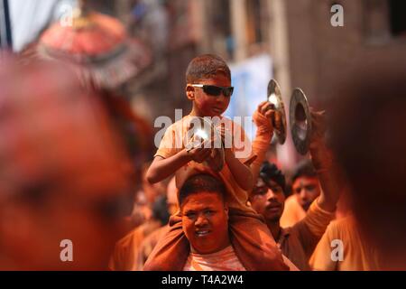 Bhaktapur, Nepal. 15 Apr, 2019. Eine nepalesische Junge nimmt mit seinem Vater in der Feier der Sindoor Jatra Festival in Thimi in Bhaktapur, Nepal, 15. April 2019. Das Festival wird gefeiert der Nepalesischen neues Jahr und den Beginn der Frühjahrssaison in Nepal zu begrüßen. Credit: Sunil Sharma/Xinhua/Alamy leben Nachrichten Stockfoto