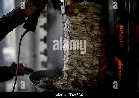 Frische Shwarma gemacht auf dem Grill und Grill Mann schneidet die Shwarma zu dienen. Stockfoto