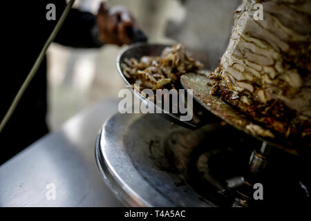 Frische Shwarma gemacht auf dem Grill und Grill Mann schneidet die Shwarma zu dienen. Stockfoto