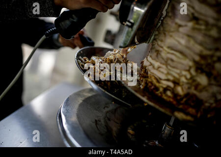 Frische Shwarma gemacht auf dem Grill und Grill Mann schneidet die Shwarma zu dienen. Stockfoto