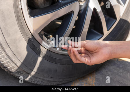 Ein Mann prüft den Reifendruck. Stockfoto