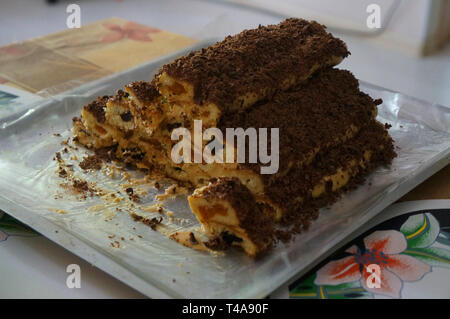 Hausgemachte Kuchen in der Form der Hütte mit Karamell, Trockenpflaumen und getrocknete Aprikosen, mit Chocolate Chips dekoriert Stockfoto