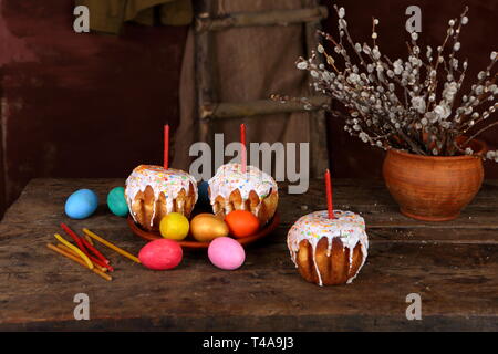 Stillleben mit bemalte Eier, Ostern Kuchen, Kerzen auf einem dunklen Holztisch Stockfoto