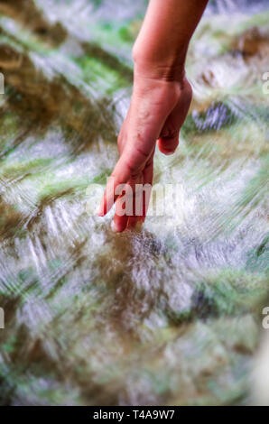 Wasser, Quelle des Lebens, und die Hand eines Jungen Stockfoto