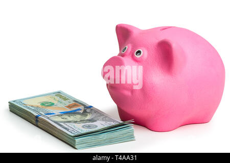 Rosa Sparschwein und Haufen von US-Dollar auf weißem Hintergrund Seitenansicht Stockfoto