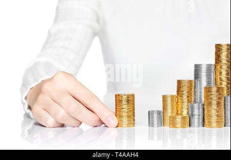 Hand hinzufügen Einer der Münzen zu Einsparungen Stapel Stockfoto