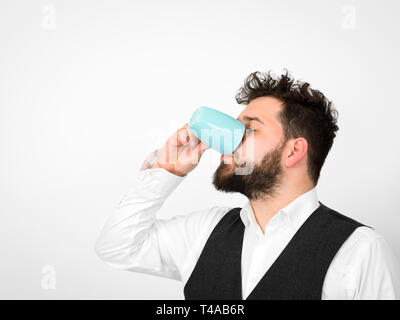 Gut aussehender, junger Mann mit schwarzen Bart mit Türkis Tasse Kaffee oder Tee Tasse vor weißem Hintergrund posiert und die verschiedenen Gesichtsausdrücke Stockfoto