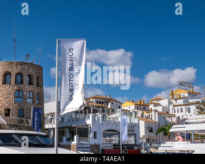 Puerto Banus Fahne Flagge im Wind flattern die Förderung der luxuriöse Yachthafen und Super Yachten von Puerto Banus, Marbella, Andalusien, Costa del Sol, Spanien Stockfoto