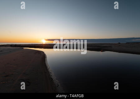 Rot leuchtenden Sonnenuntergang an der Ostsee mit Spiegel wie Wasser - Veczemju Klintis, Lettland - 13 April, 2019 Stockfoto