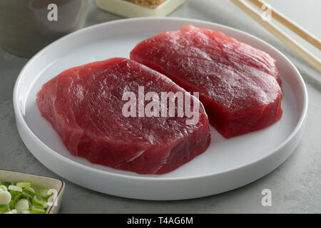 Teller mit zwei frischen, rohen Gelbflossenthun Steaks aus der Nähe Stockfoto