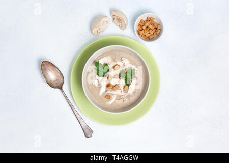 Pilzsuppe in einer weißen Schüssel, Champignons, Croutons, frische Grün auf weißem Hintergrund. Blick von oben. Kopieren Sie Platz Stockfoto