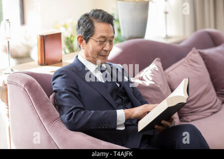 Senior Edelmann Lesung im Wohnzimmer Stockfoto