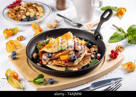 Pfannkuchen mit Beeren und Schokolade Sauce Braten serviert pan am Tisch im Restaurant Stockfoto