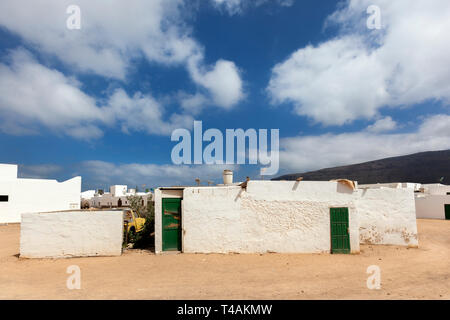 Leere Straße mit Sand und weißen Häusern und einem Boot in Caleta de Sebo auf der Insel La Graciosa Lanzarote Stockfoto