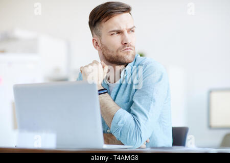 Stattlicher Mann mit Laptop zu Hause Stockfoto