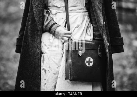 Re-Enactor trägt Historische deutsche Krankenschwester Sanitäter des Zweiten Weltkriegs Uniform mit Erste Hilfe Kit. Foto in den Farben Schwarz und Weiß. WWII WW2. Stockfoto