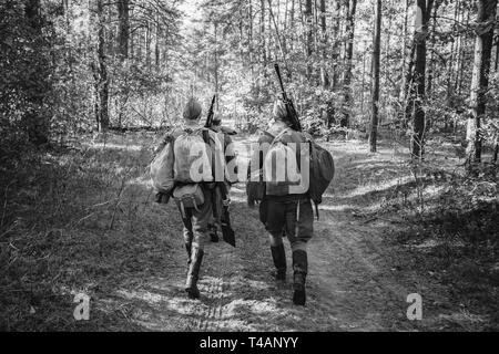 Zwei Re-enactors als Zweiter Weltkrieg russisch-sowjetischen Soldaten der Roten Armee Marschieren durch den Wald gekleidet. Foto in den Farben Schwarz und Weiß. Soldat des zweiten WELTKRIEGS WW2 Stockfoto