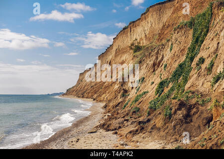 Wunderschöne Aussicht auf sandigen Felsen in der Nähe Meer Strand. Landschaft von Felsen am Strand und Wellen. Sommer Urlaub Konzept. Erkunden Sie interessante Orte Stockfoto