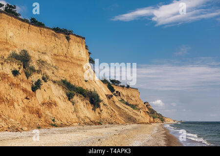 Wunderschöne Aussicht auf sandigen Felsen in der Nähe Meer Strand. Landschaft von Felsen am Strand und Wellen in sonniges Wetter. Sommer Urlaub Konzept. Erkunden Sie interessante Plac Stockfoto