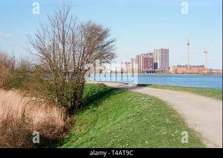 Fußweg und Behälter auf Walthamstow Feuchtgebiete, nördlich von London UK, mit neuen Wohnblocks im Hintergrund Stockfoto