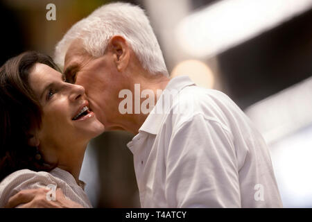 Mann mittleren Alters seine Frau Küssen auf die Wange. Stockfoto