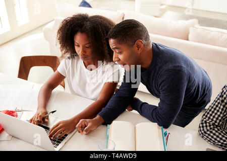 Schwarze Mädchen im Teenageralter Hausaufgaben mit Hilfe von ihrem Papa, bei Computer Bildschirm schaut, Erhöhte Ansicht Stockfoto