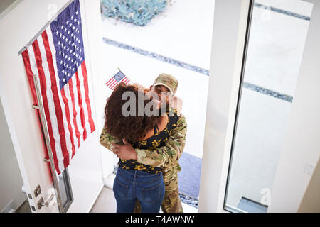 Ansicht der Rücksendung männlichen Schwarzen Soldat seine Frau umarmt in der Tür ihres Hauses Stockfoto