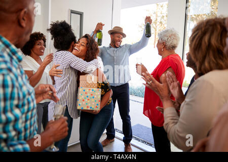 Tausendjährige schwarz Paar bei einer Familienfeier mit Geschenken und Champagner anreisen, in der Nähe Stockfoto