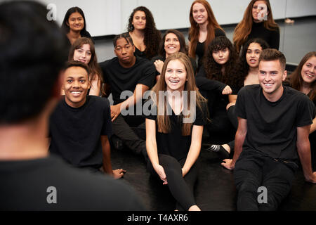 Lehrer an der Schule für darstellende Kunst im Gespräch mit Studenten sitzen auf dem Boden in Rehearsal Studio Stockfoto