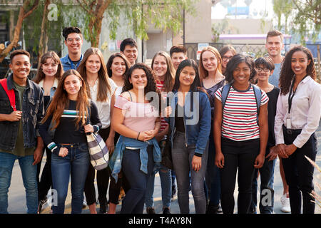 Portrait von lächelnden Männliche und weibliche Studenten mit Lehrer außerhalb der Schule Gebäude Stockfoto