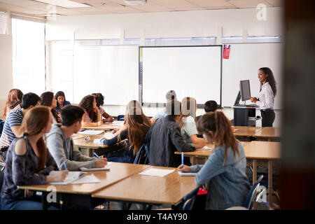 Female High School Lehrer durch interaktive Whiteboard Lehre Lehre stehend Stockfoto