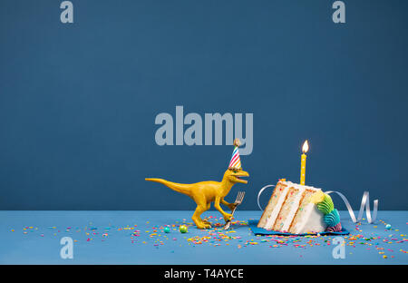 Spielzeug Dinosaurier Holding eine Gabel und Ausblasen Geburtstag Kerze auf einem blauen Hintergrund Stockfoto