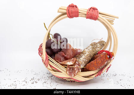 Warenkorb Wurst Wurst, trockene Wurst, Coppa, Lonzu und Chorizo ​​And rote Trauben, in einem Korb zarzo Stockfoto