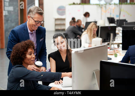 Unternehmer und Unternehmerinnen Arbeiten am Computer auf dem Schreibtisch im Großraumbüro Stockfoto