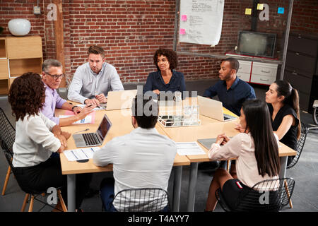 Gruppe von Unternehmern und Unternehmerinnen Treffen rund um Office Tabelle Stockfoto