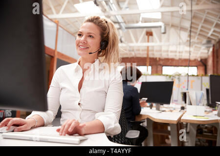 Weibliche Kunden Services Agent Arbeiten am Schreibtisch in Call Center Stockfoto