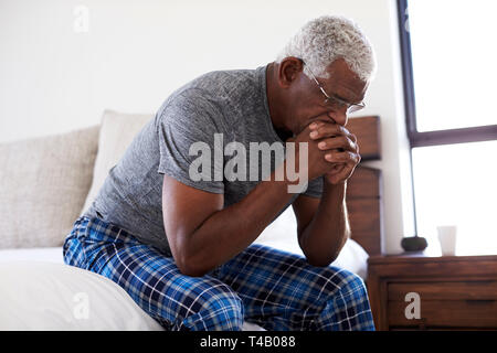 Deprimiert älterer Mann suchen Unglücklich sitzt seitlich am Bett zu Hause mit dem Kopf in den Händen Stockfoto