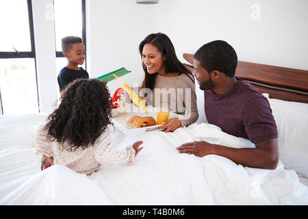 Kinder, die ihre Mutter Frühstück im Bett zu feiern Muttertag oder Geburtstag Stockfoto