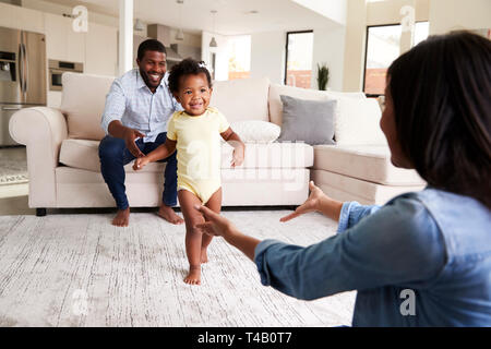 Familie zu Hause Förderung Baby Tochter Erste Schritte Stockfoto