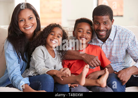 Porträt der Familie sitzt auf dem Sofa zu Hause Lächeln an Kamera Stockfoto